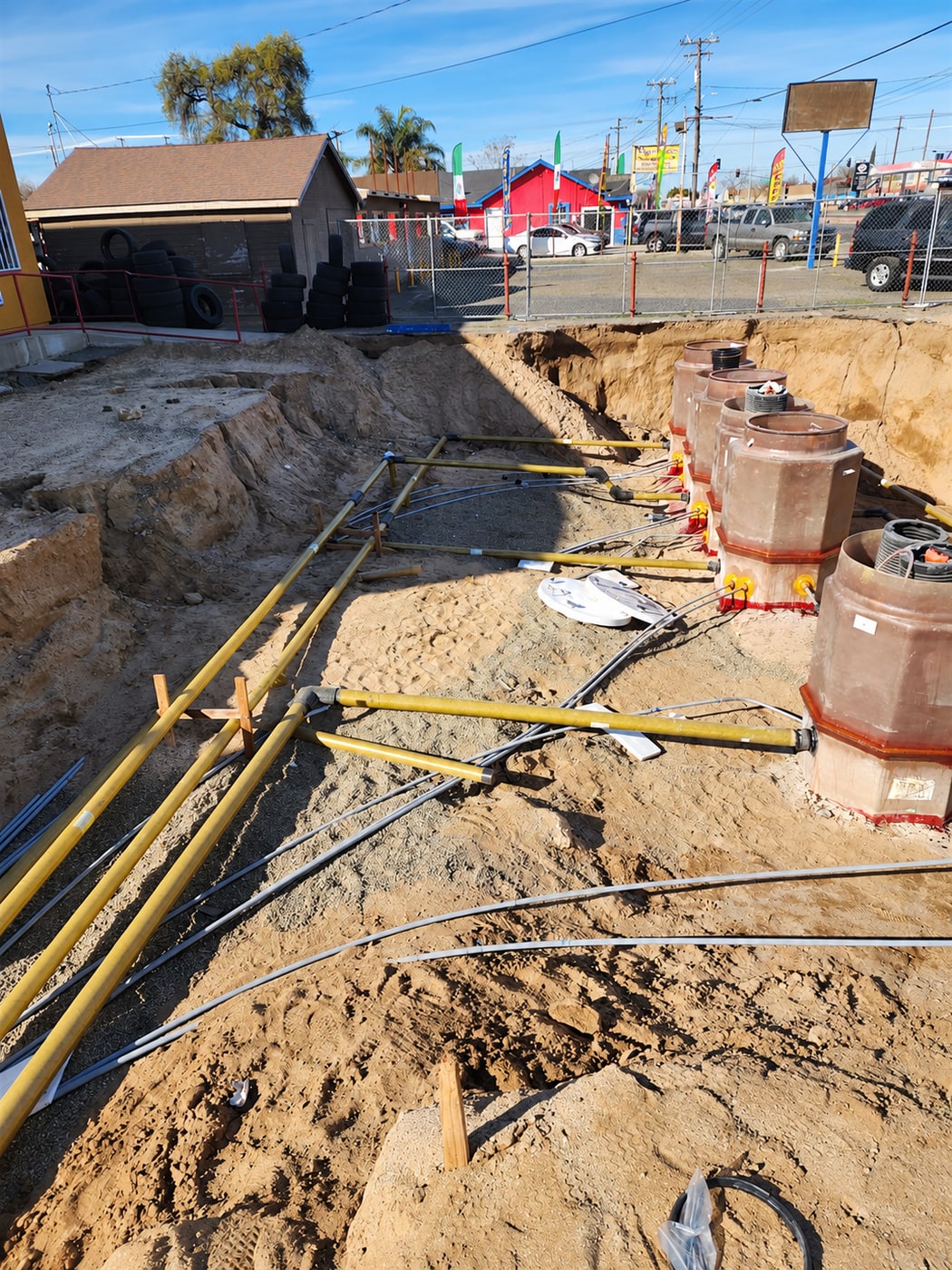 Fuel system containment sumps and piping installed in an excavated trench
