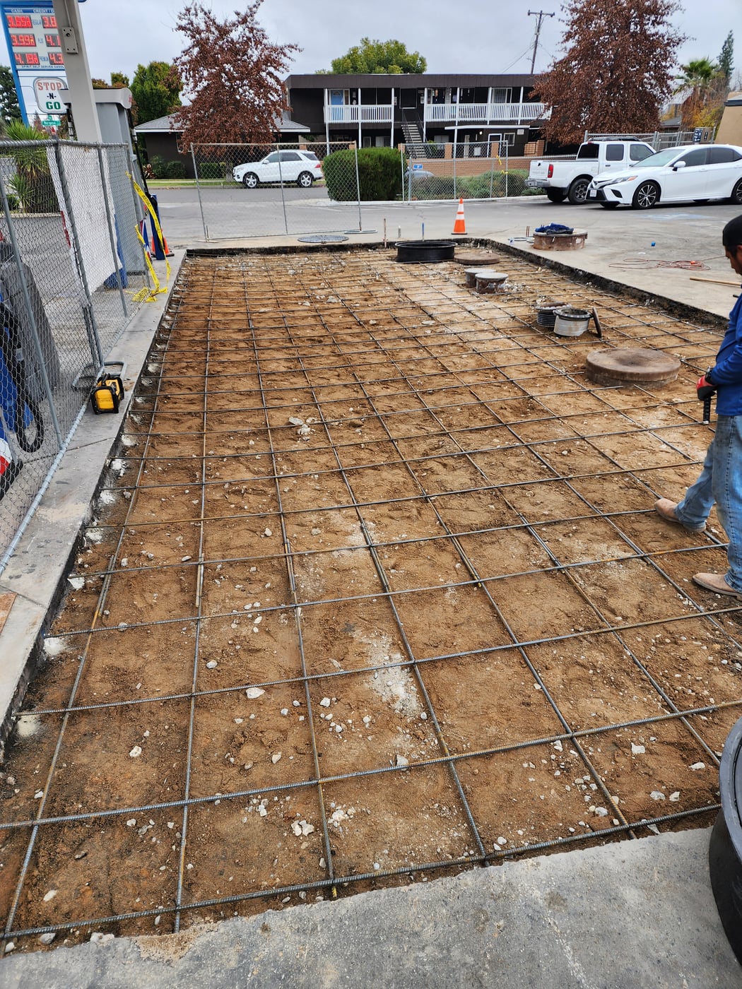 Rebar grid surrounding tank access covers before a concrete slab is poured