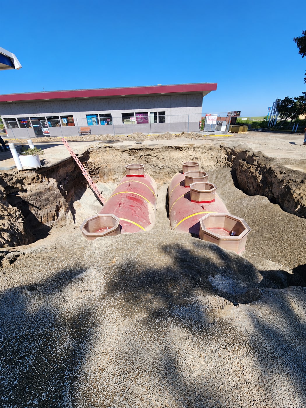 New underground fuel tanks set in excavation with backfill material